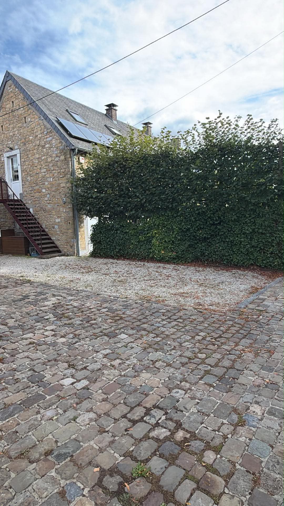 Emplacement de parking sur les graviers, à ne pas confondre avec les pavés au premier plan